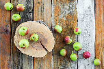 Image showing Apple tree stump and apples on rustic wooden background