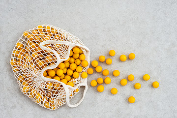 Image showing Lots of yellow plums in a mesh shopping bag