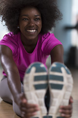 Image showing woman in a gym stretching and warming up before workout