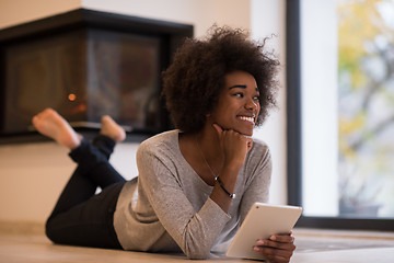 Image showing black women using tablet computer on the floor