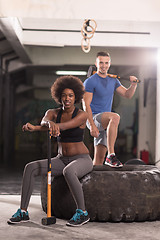 Image showing multiethnic couple after workout with hammer