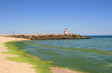 Image showing Beach with pier og lighthouse