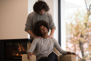 Image showing multiethnic couple hugging in front of fireplace