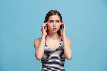 Image showing Let me think. Doubtful pensive woman with thoughtful expression making choice against blue background