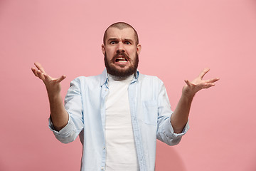 Image showing Beautiful male half-length portrait isolated on pink studio backgroud. The young emotional surprised man