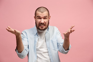 Image showing Beautiful male half-length portrait isolated on pink studio backgroud. The young emotional surprised man