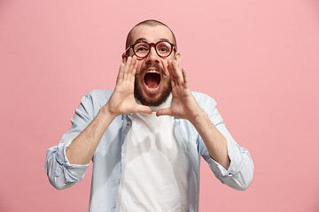 Image showing Isolated on pink young casual man shouting at studio