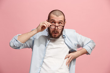 Image showing Let me think. Doubtful pensive man with thoughtful expression making choice against pink background