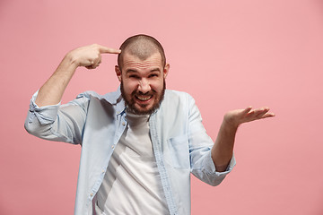 Image showing Beautiful male half-length portrait isolated on pink studio backgroud. The young emotional surprised man