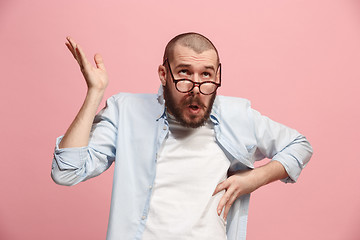 Image showing Let me think. Doubtful pensive man with thoughtful expression making choice against pink background