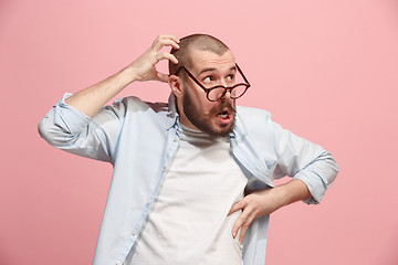 Image showing Let me think. Doubtful pensive man with thoughtful expression making choice against pink background