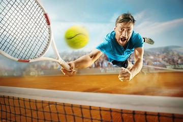 Image showing The one jumping player, caucasian fit man, playing tennis on the earthen court with spectators