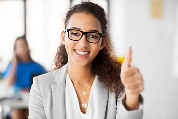 Image showing smiling african woman showing thumbs up at office