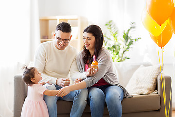 Image showing baby girl with parents at home birthday party