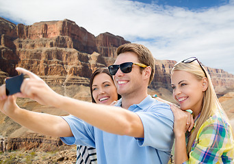 Image showing group of happy friends taking selfie by cell phone