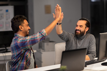 Image showing creative team making high five at night office