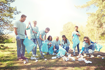 Image showing volunteers with garbage bags cleaning park area