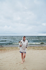 Image showing Young lady with dog near sea