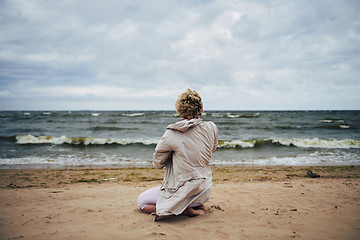 Image showing Anonymous woman in jacket looking at sea