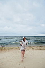 Image showing Young lady with dog near sea