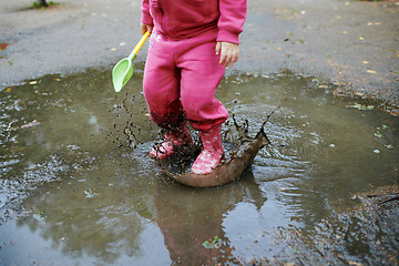 Image showing Child jumps in a dirty puddle