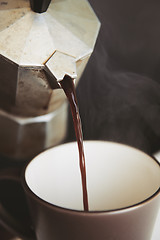 Image showing Hot coffee is poured from mokacoffee maker