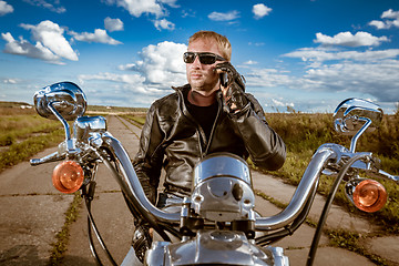 Image showing Biker talking on a smartphone.