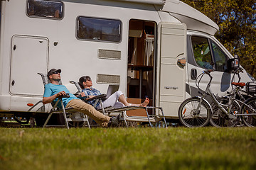 Image showing Woman with a man resting near motorhomes in nature. Family vacat