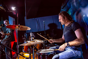 Image showing Drummer playing on drum set on stage.