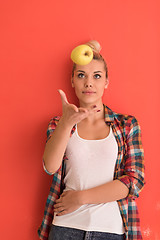 Image showing woman over color background plays with apple