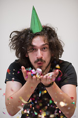 Image showing man blowing confetti in the air