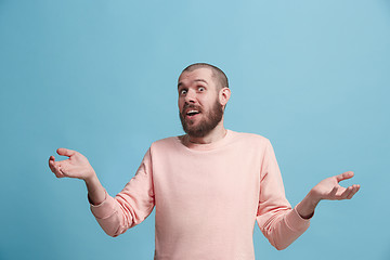 Image showing The young attractive man looking suprised isolated on blue