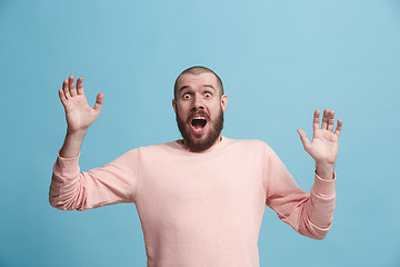 Image showing The young attractive man looking suprised isolated on blue