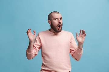 Image showing The young attractive man looking suprised isolated on blue