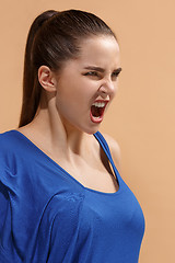 Image showing The young emotional angry woman screaming on pastel studio background