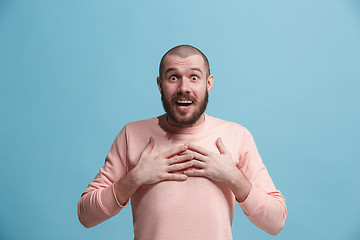 Image showing The young attractive man looking suprised isolated on blue