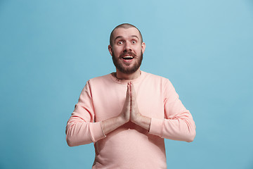 Image showing The young attractive man looking suprised isolated on blue