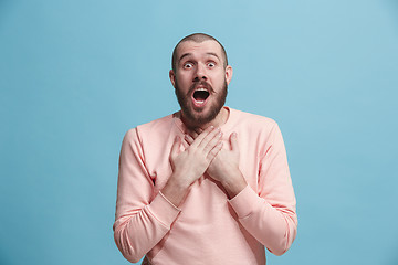 Image showing The young attractive man looking suprised isolated on blue