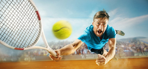 Image showing The one jumping player, caucasian fit man, playing tennis on the earthen court with spectators