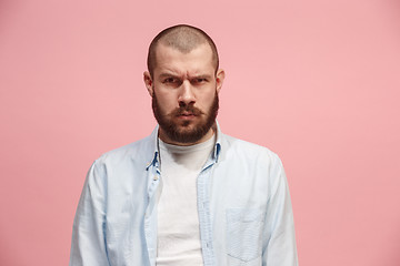 Image showing The serious businessman standing and looking at camera against pink background.