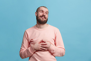 Image showing The happy businessman standing and smiling against blue background.