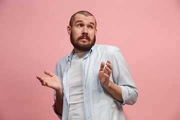 Image showing Let me think. Doubtful pensive man with thoughtful expression making choice against pink background