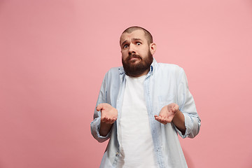 Image showing Let me think. Doubtful pensive man with thoughtful expression making choice against pink background