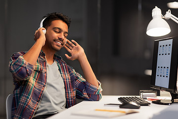 Image showing man with headphones listening to music at office