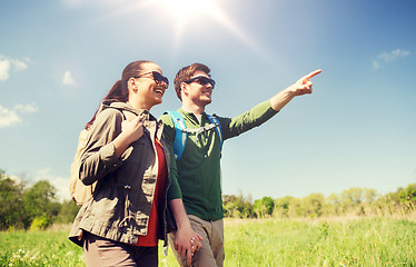 Image showing happy couple with backpacks hiking outdoors