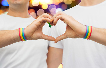 Image showing gay couple with rainbow wristbands and hand heart