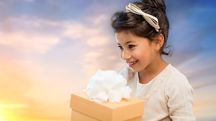 Image showing happy girl with gift box over evening sky