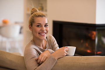 Image showing woman with a mug near a fireplace