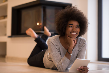 Image showing black women using tablet computer on the floor