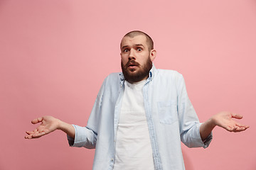 Image showing Let me think. Doubtful pensive man with thoughtful expression making choice against pink background